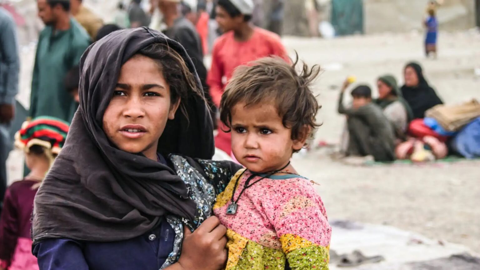 A woman and child in the middle of a crowded street.