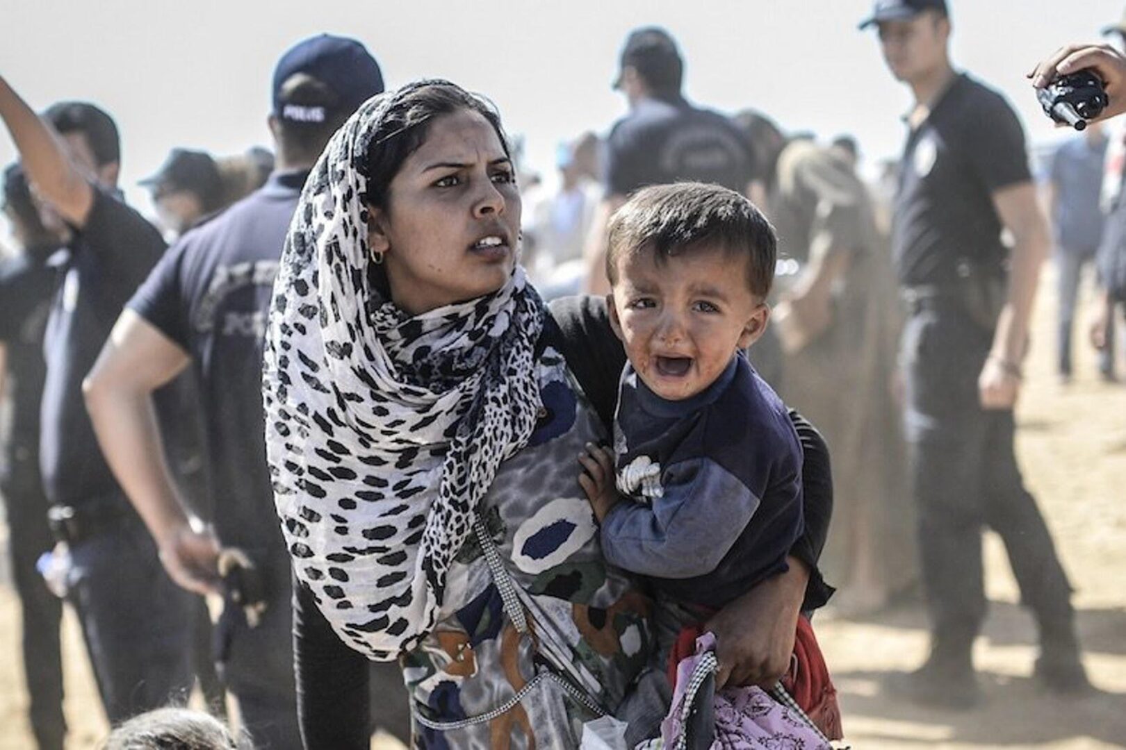 A woman and child are walking in the street.