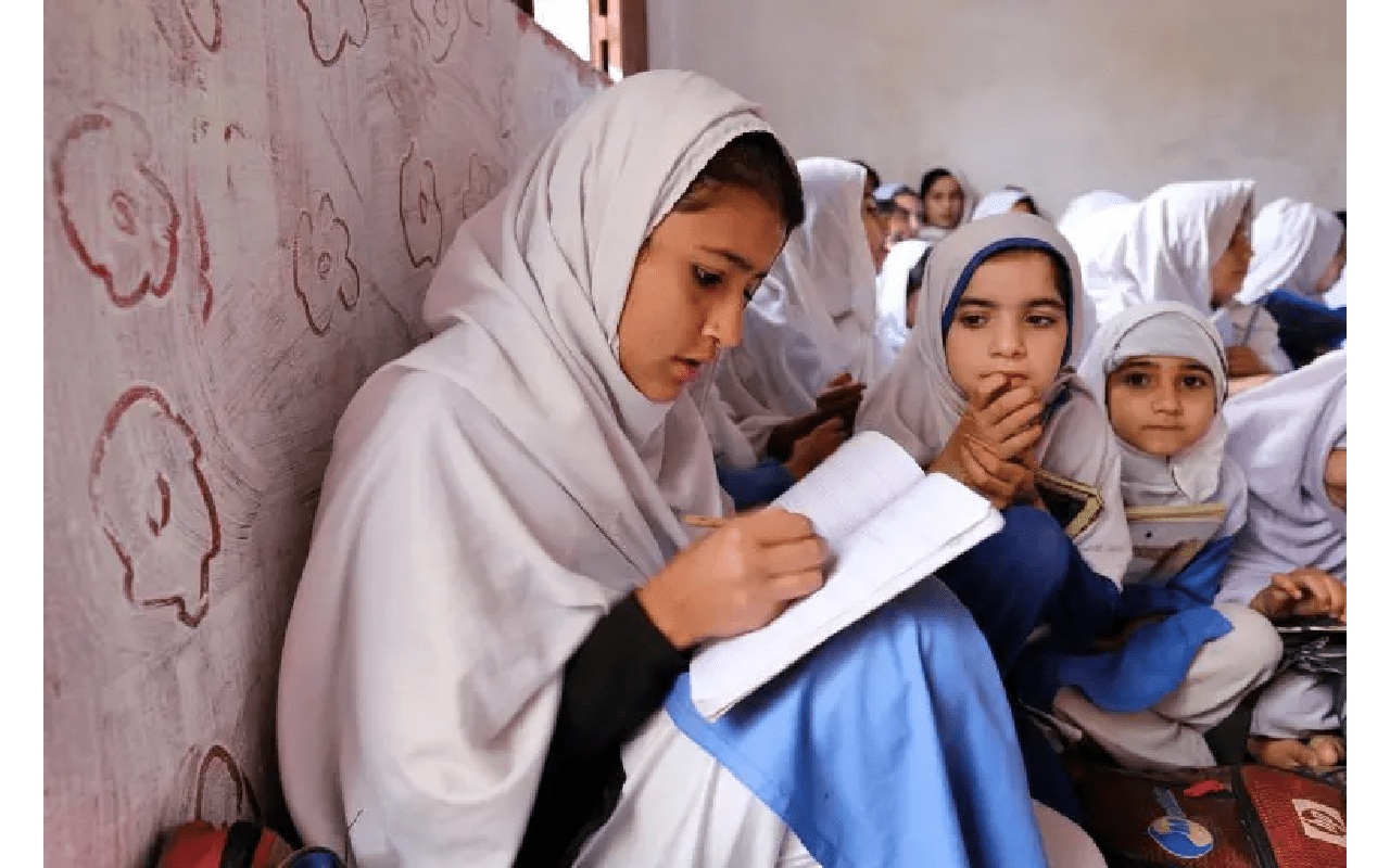 A group of girls sitting in a room reading.