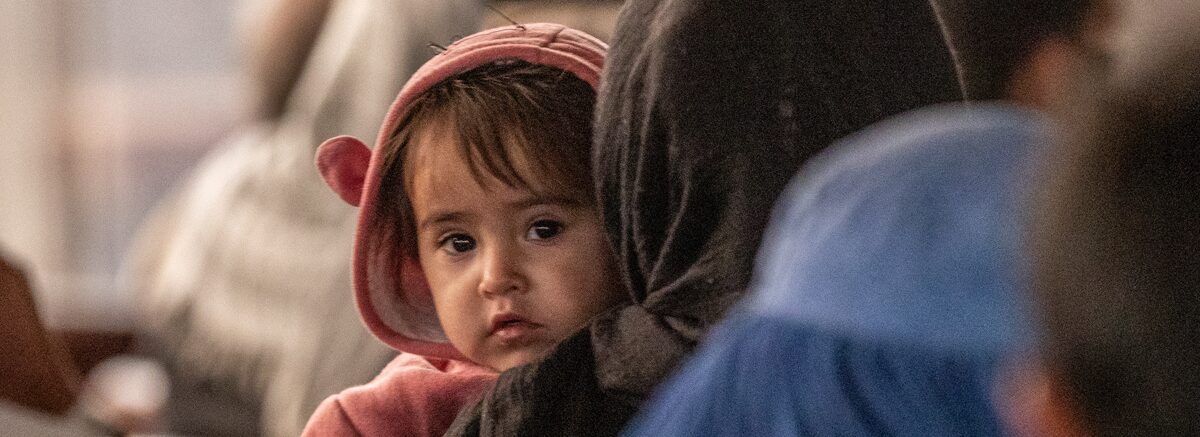 A young child is looking at the camera.